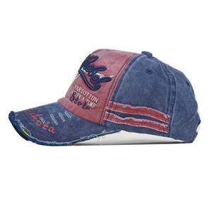 Detail of distressed navy denim baseball cap with Rebel embroidery and vintage texture