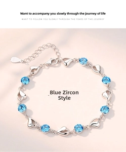 Detail of S925 silver bracelet featuring blue zircon stones and hollow heart charms
