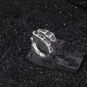 S925 Sterling Silver snake ring with multi-colored gemstones on a textured background
