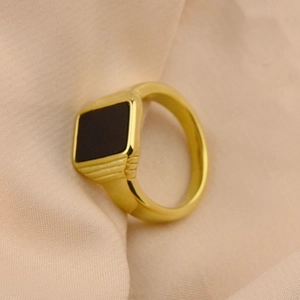 Close-up of a gold-plated stainless steel signet ring with a black square center