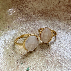 Close-up of vintage S925 silver gold-plated open rings with Mary shell relief detail