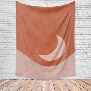 Detail of bohemian sun and moon tapestry hanging on a white brick wall in a cozy room