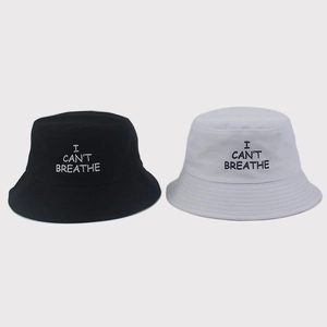 Detail view of black and white cotton bucket hats featuring I CAN'T BREATHE embroidery