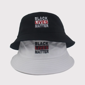 Detail of embroidered Black Lives Matter slogan on cotton bucket hats in black and white
