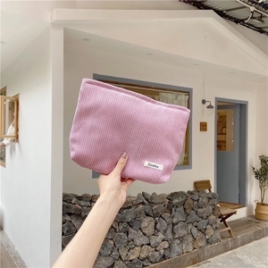Detailed close-up of pink corduroy texture on a cosmetic bag with a small white label