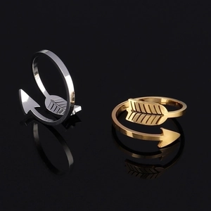 Detail of arrow-shaped open rings in gold and silver finish with polished metal texture