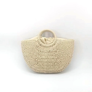 Detail of half-moon straw woven bag featuring a round handle and natural woven texture