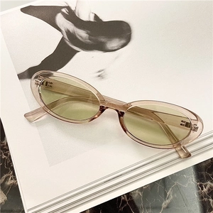 Detailed macro view of retro oval sunglasses with translucent amber frames and yellow lenses