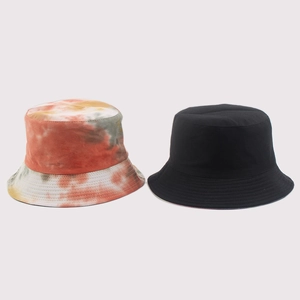 Close-up of colorful tie-dye and solid black cotton canvas bucket hats with reinforced brims