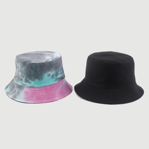 Detail view of colorful tie-dye and classic black cotton canvas bucket hats with stitching