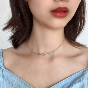 Detailed close-up of a 925 silver and gold tone interlocking knot pendant necklace