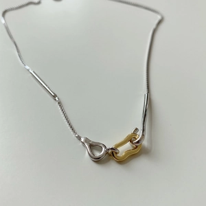 Macro shot of 925 sterling silver geometric link pendant with gold and silver finish