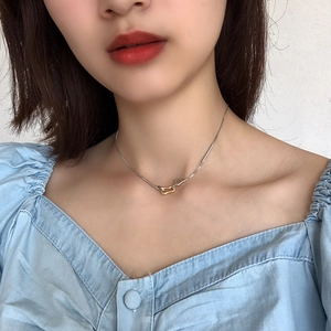Close-up of a minimalist 925 silver necklace with interlocking gold and silver geometric rings