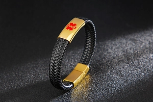 Detail view of black braided leather medical alert bracelet with golden metal clasp