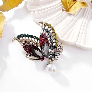 Elegant vintage gold butterfly brooch with colorful rhinestones and a white pearl drop