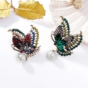 Exquisite butterfly brooches with colorful rhinestones and pearls on a white background