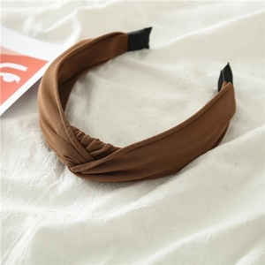 Detailed view of a brown knotted fabric headband with textured cotton linen weave