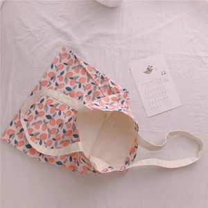 Detailed top view of floral cotton tote bag with interior pocket and fruit pattern print
