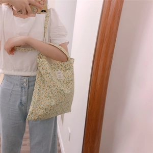 Detail of floral canvas tote bag with yellow and white flower pattern and fabric label