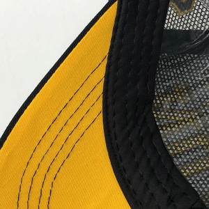 Close-up of yellow brim stitching and black breathable mesh on baseball cap