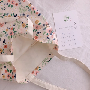 Detailed macro view of the cream floral canvas tote with neat stitching and poly-cotton lining