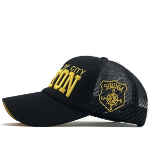 Close-up of black mesh baseball cap with yellow OF CITY 3D embroidery on the side