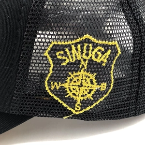 Close-up of a breathable black mesh trucker hat with a yellow compass embroidery