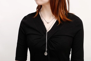 Close-up of double-layered silver-tone necklace with minimalist pendant on a model