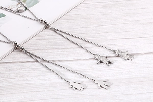 Detail of silver double layer necklace with boy and girl pendants and heart detail