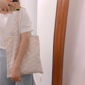 Floral cotton tote bag with pink flower pattern shown being worn on the shoulder