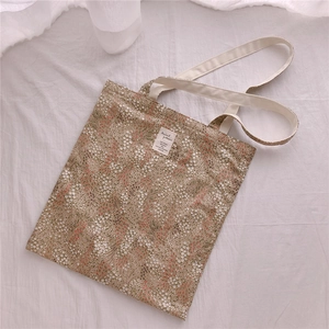 Close-up of a floral cotton tote bag with a white fabric label and intricate patterns