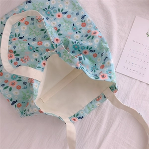 Detail of floral canvas tote bag with pastel flower patterns and sturdy cotton handles