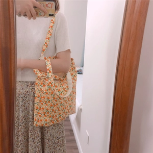 Close-up of cream cotton tote bag featuring vibrant orange and yellow citrus floral prints