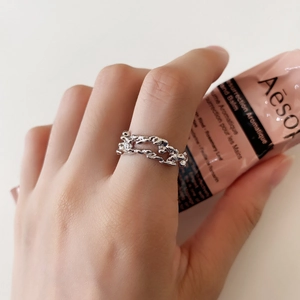 Close-up of silver S925 ring with irregular lava texture worn on a finger