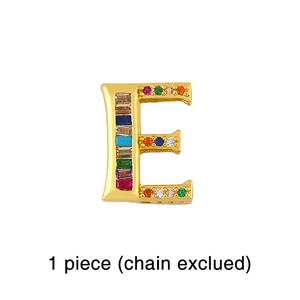 Macro detail of gold letter E charm pendant with rainbow baguette and round zircons