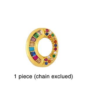 Detailed macro of gold letter O pendant with colorful crystals and pavé settings