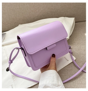 Close-up of light purple square crossbody bag featuring a knotted strap and flap closure