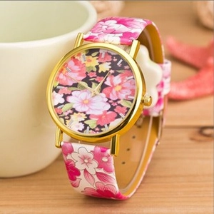 Primo piano dell'orologio da donna Ginevra con quadrante floreale rosa e cinturino in oro