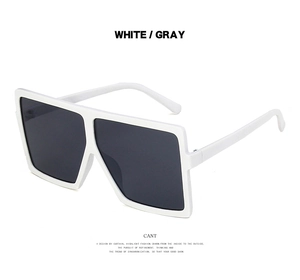 Detail view of white oversized square sunglasses with dark gray lenses in retro style
