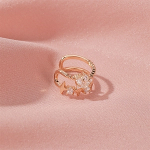 Dettaglio dell'orecchino a clip a stella in oro rosa con zirconi su seta rosa