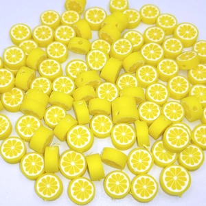 Macro shot of 10mm yellow lemon polymer clay beads for jewelry making and DIY crafts