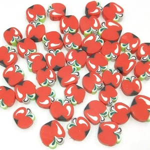 Detail of red apple clay beads with side holes for DIY jewelry making and crafts