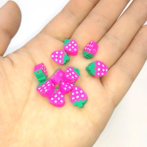 Macro shot of 10mm pink polymer clay strawberry beads for DIY jewelry making