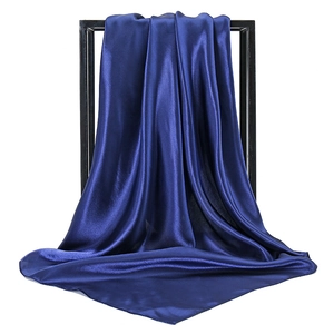 Detail of navy blue satin square scarf with premium silk texture and glossy finish