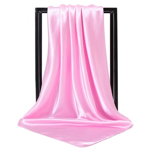 Pink satin square scarf with a silky finish hanging on a black minimalist frame