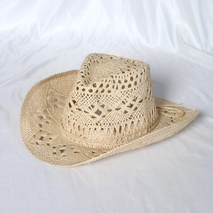 Detail of hand-woven hollow mesh pattern on beige straw cowboy hat with a curved brim