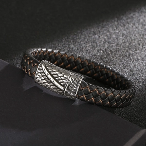 Men's braided leather bracelet with silver feather engraved magnetic clasp on dark stone