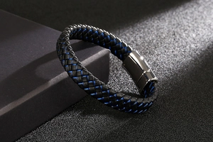 Macro shot of men's braided leather bracelet with gunmetal magnetic clasp and blue stitching