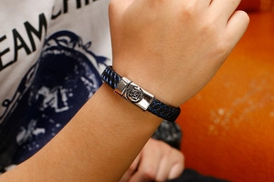 Detail of blue and black woven men's bracelet with engraved nautical anchor buckle