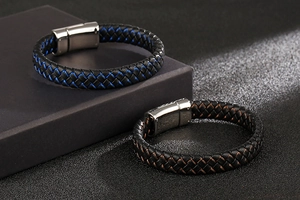 Detail of woven leather bracelets with skull charms and magnetic metal clasps